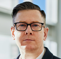 Portrait of Alexander Hughes, executive leading a cryptocurrency trading company